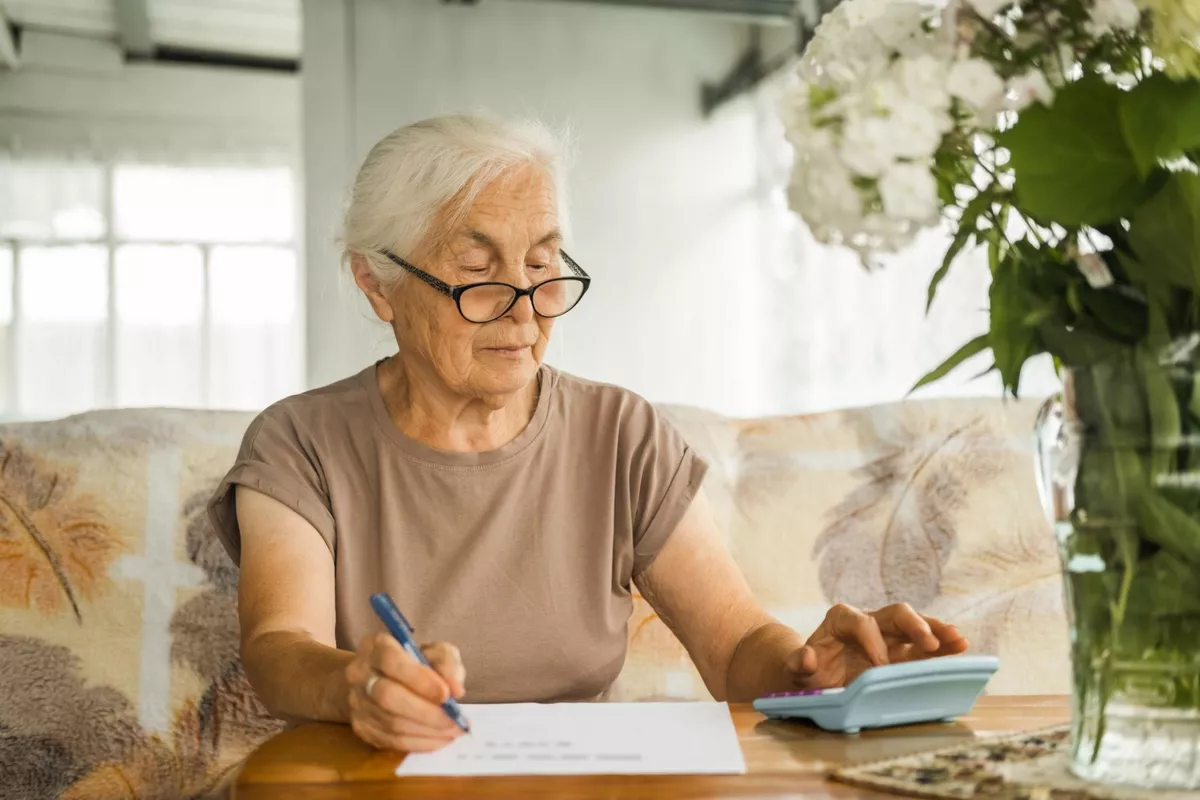 Femme de 64 ans calculant ses revenus pour anticiper les effets du cumul emploi-retraite